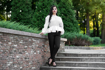 Portrait of a beautiful, young and attractive Caucasian brunette girl. Elegant girl posing in the summer in the park. Fashion concept.