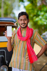Indian auto rickshaw three-wheeler taxi driver man showing smartphone.