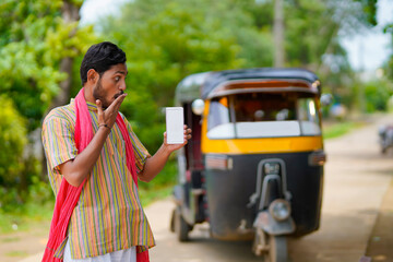 Indian auto rickshaw three-wheeler tuk-tuk taxi driver man showing smartphone