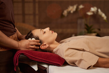 Obraz na płótnie Canvas Patient dozing during head massage performed by masseuse