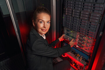 Computer technician working with backup server in racks