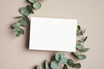 Greeting or wedding invitation card mockup with natural eucalyptus twigs.