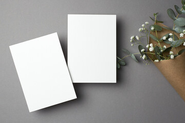 Wedding invitation card mockup with copy space, front and back sides, eucalyptus and gypsophila flowers.