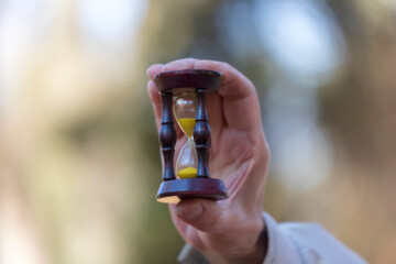 Hourglass in the hands of an old man who understands that life is short