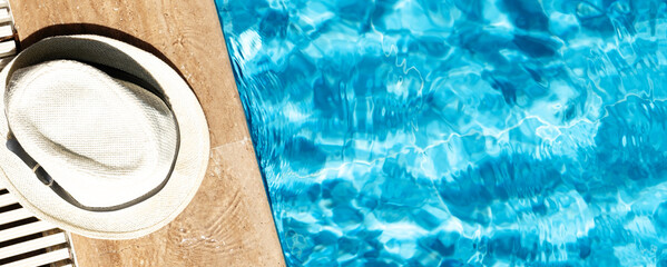 Summer banner with hat near swimming pool. Hot sunny vacation concept. Top view. Copy space
