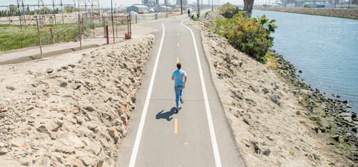 mature athletic man running on road outdoor, sprinter