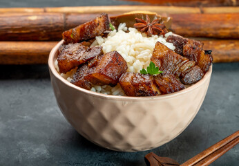 Bowl with rice and braised pork and half a pickled egg in soy sauce Asian style eggs, close-up.