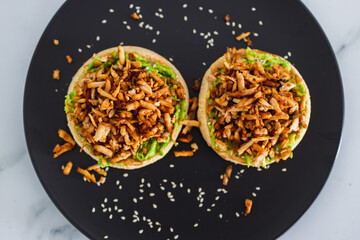 vegan shredded marinated teriyaki tofu with avocado guacamole on top of English muffins, healthy plant-based food