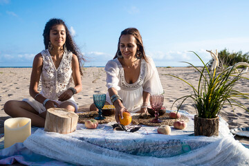 Smiling woman doing picnic arrangement with friend on beach