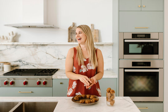 Cheerful female professional preparing healthy food at kitchen counter