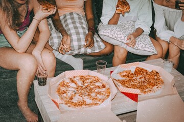 Friends eating pizza, hanging out at a sleepover party