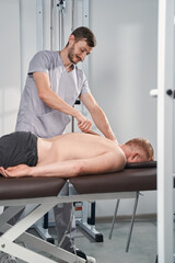 Fototapeta premium Man doctor back massages with steel scraper for patient with back pain
