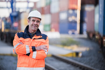 Happy male blue-collar worker with arms crossed in dock