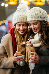 Happy woman friends enjoying time together on christmas market. People happiness concept