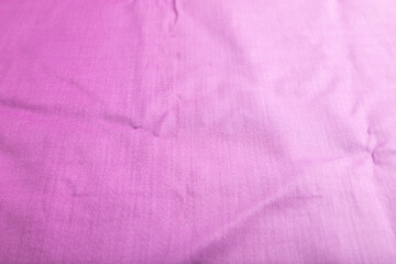 Fragment of smooth cotton purple tissue. Side view, natural textile background.