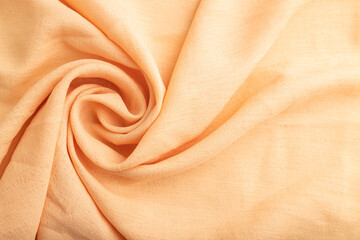 Fragment of orange linen tissue. Top view, natural textile background.