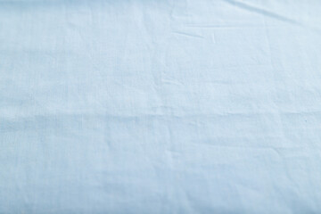 Fragment of smooth cotton blue tissue. Side view, natural textile background.