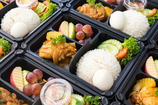 Thai food lunch boxes in plastic packages. Rice with Thai chicken massaman curry.
