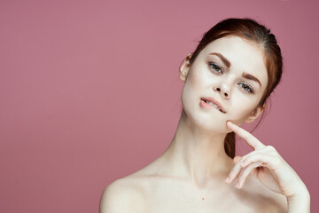 woman with bare shoulders charm cosmetics pink background posing
