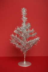 70s retro Silver Christmas Tinsel Tree on a red background 