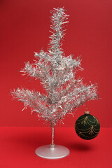 Silver Tinsel Christmas tree isolated on a red background