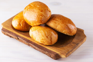 Homemade baked pies on a wooden plate. © 7707601