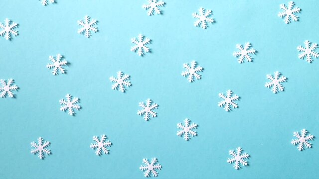 White snowflakes on the blue background stop motion animation. Christmas, new year, winter background