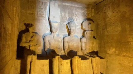 Little and sacred four statues in the interior of Abu Simbel temple illuminated by sunlight at sunrise. Concepts of Egyptian chambers. Representations of the gods in the ancient egyptology.
