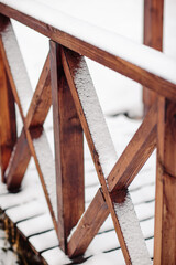 Wooden bridge covered with snow. First snow on the street.