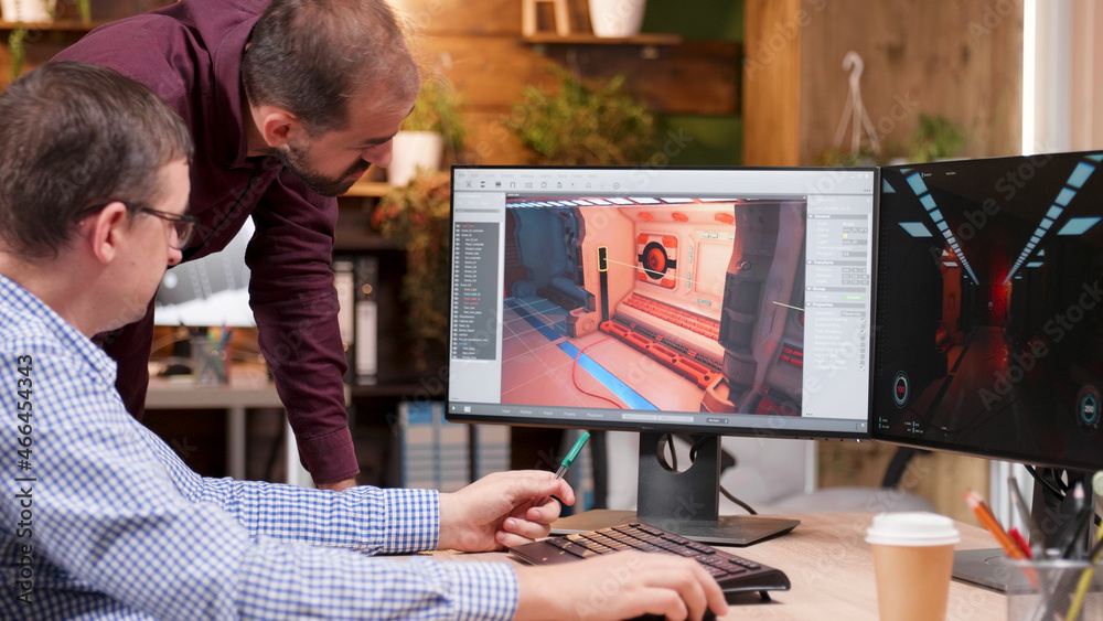 Fototapete graphic designer in gaming industry talking detail with his colleague analyzing 3d design level expl