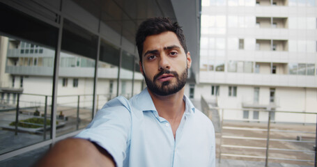 Pov shot of bearded businessman having video call outside business center