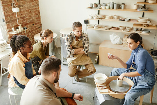 High angle view at diverse group of people at pottery workshop in cozy studio, copy space