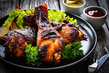 Barbecue chicken drumsticks with fresh vegetables on wooden table
