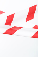 Obraz premium Red and white striped fencing tape on a white background.