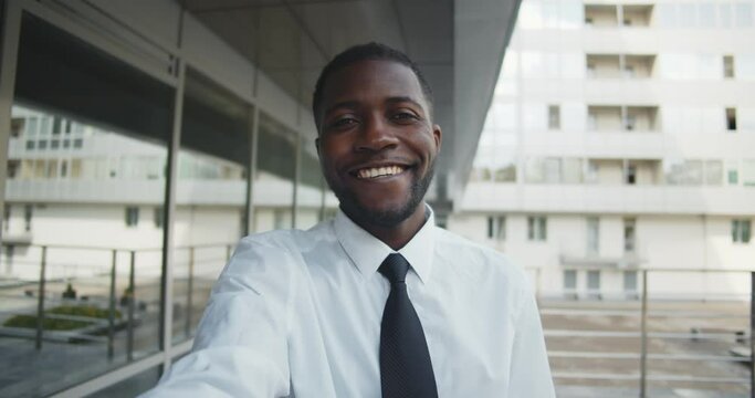 Pov shot of smiling mixed-race businessman having video call outdoors