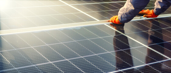 Close-up of hands worker installing solar cell farm power plant eco technology.landscape of Solar...