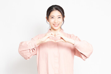 手でハートの形を作って愛情を表現する女性