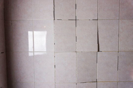 Old cracked tile in the bathroom, Cracked tile on the bathroom wall needs repair. Construction problems