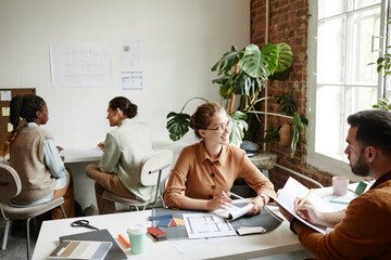 Portrait of diverse creative team working in modern studio lit by sunlight, copy space