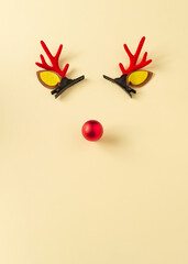 Reindeer horns with a red nose on yellow background. New Year's mood. Free space for greetings.