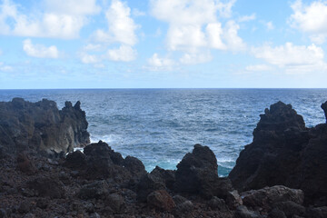 Scenic view of the Pacific Ocean through black volcanic rock landscape on the island of Maui, Hawaii