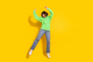 Full size photo of attractive young positive woman jump up good mood crazy isolated on shine yellow color background