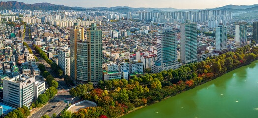 Aerial panoramic view of Seokchon lake and surrounding buildings with autumn colors, Jamsil, Songpa-gu, Seoul, South Korea.