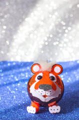 Christmas tree toy tiger symbol of the new year 2022 on a blue silver background with glitter, copy space for text