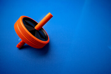 Abs roll out exercise fitness wheel on blue background
