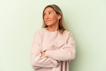 Young caucasian woman isolated on green background dreaming of achieving goals and purposes