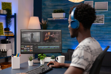 African american videographer with headphones editing video film montage analyzing visual effects using footage post production software. Videomaker retouching movie working remote from home