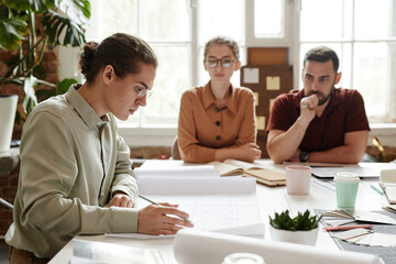 Side view portrait of young male architect in team meeting, copy space