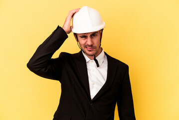 Young architect caucasian man isolated on yellow background being shocked, she has remembered important meeting.