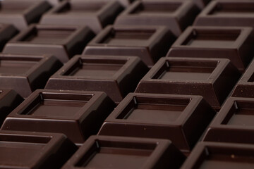 Obraz premium Close up a chocolate bar background. Chocolate bar cubes macro